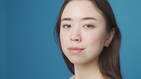 Asian-woman-looking-at-camera.-Blue-background.